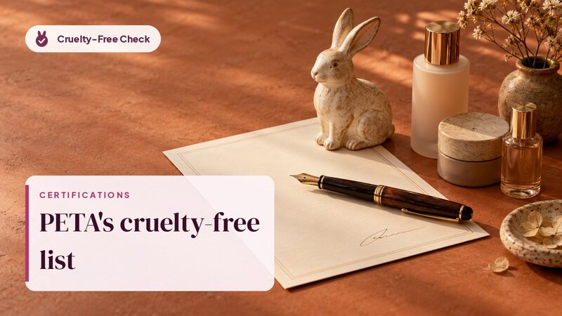 Fountain pen on a blank pledge next to a ceramic rabbit and unbranded bottles, illustrating PETA's Ultimate Cruelty-Free List